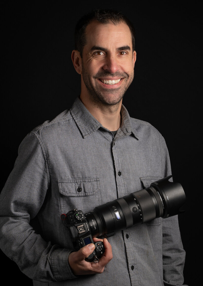 Eric Smyklo of Smyklo Photo holding Nikon Camera.