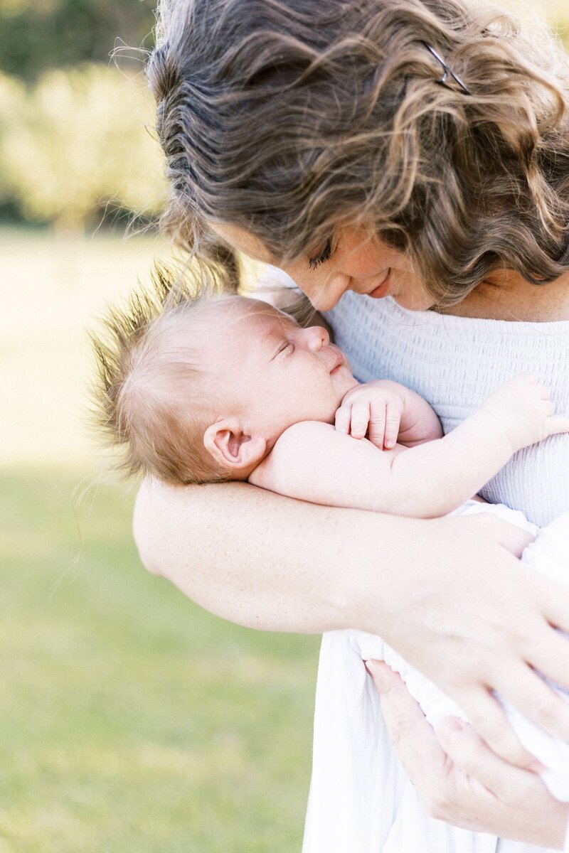 mom snuggling with newborn baby in baby photos peoria, illinois 