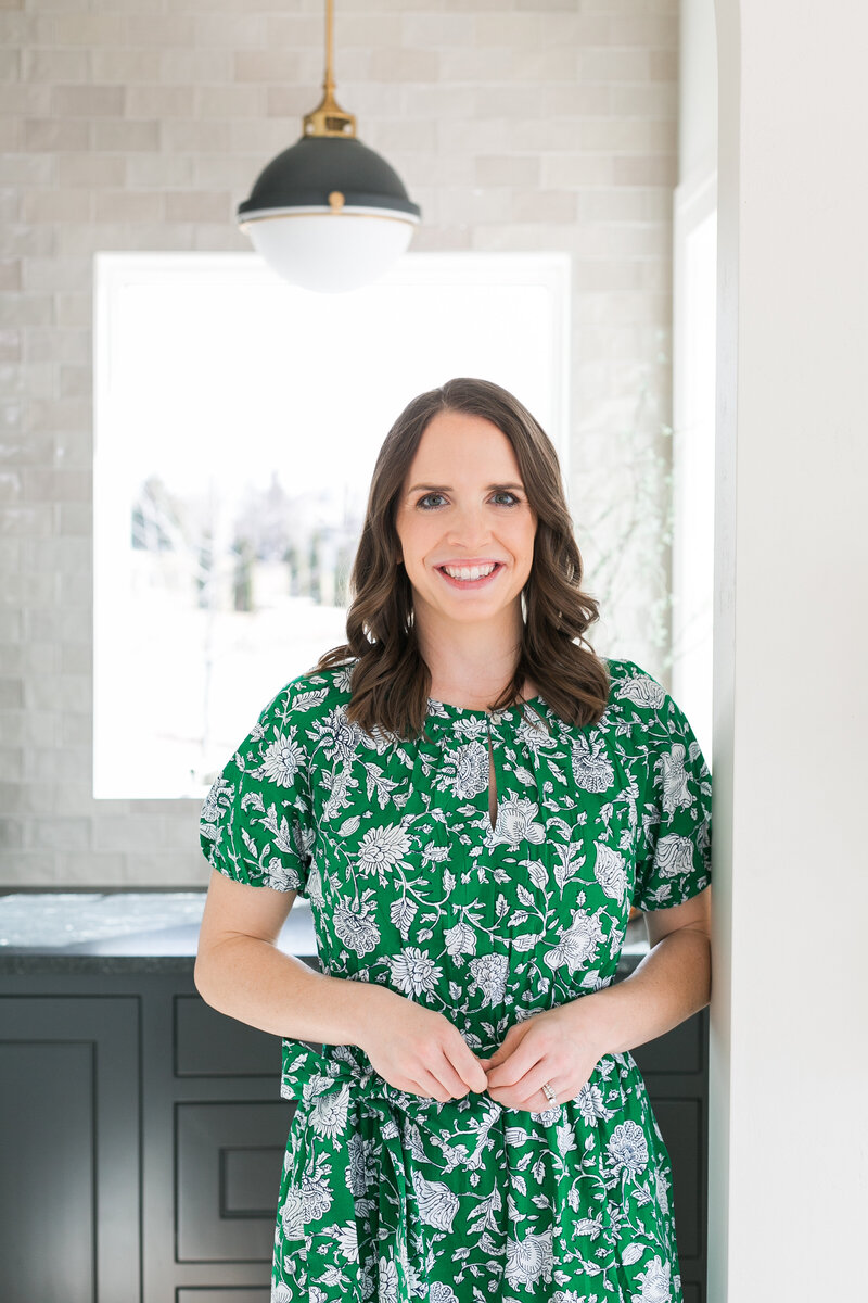 Amanda smiling in a green floral print dress