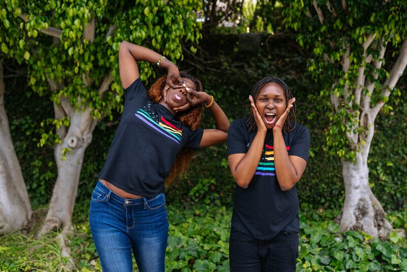 Two Women of Color Wearing Pride Shirts