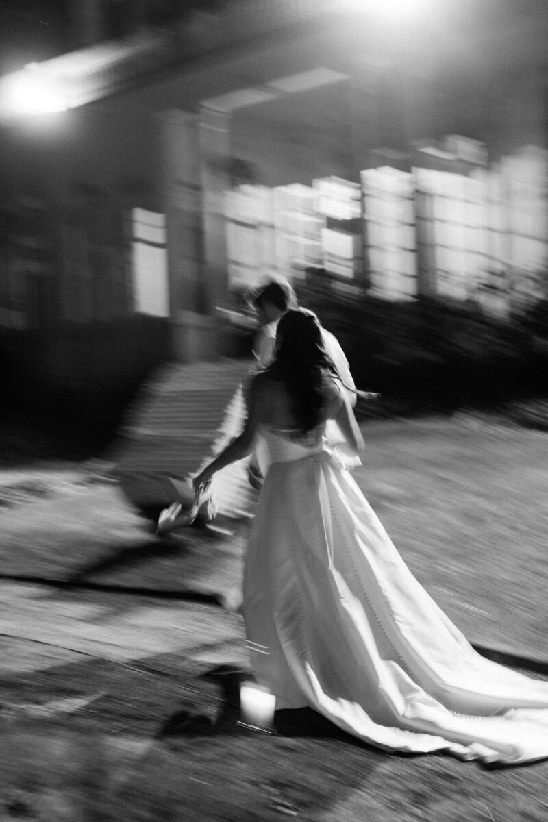 Blurry photo of bride and groom running inside at the end of the night at Glen Foerd Estate in Philadelphia, PA