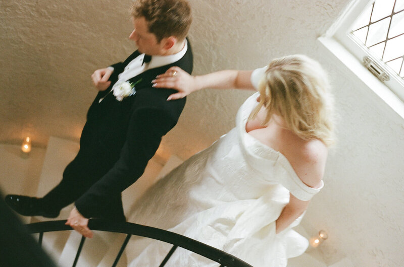 Bride and Groom walking down staircase at The edgemont Venue in Little Rock, AR.