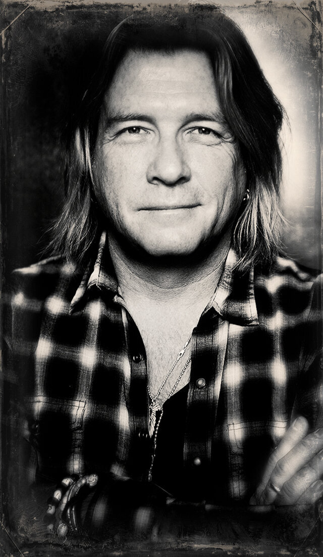 Music portrait Bob Rock black and white wearing plaid shirt arms crossed