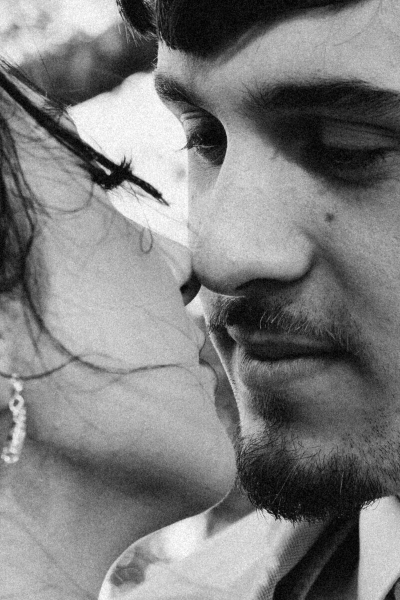 Tender black and white close-up of a bride and groom in an almost-kiss moment, filled with emotion and quiet romance