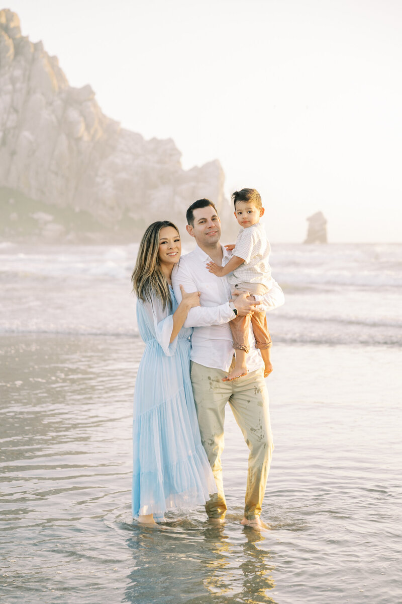 Family poses against a giant redwood tree in Santa Cruz for their family photos