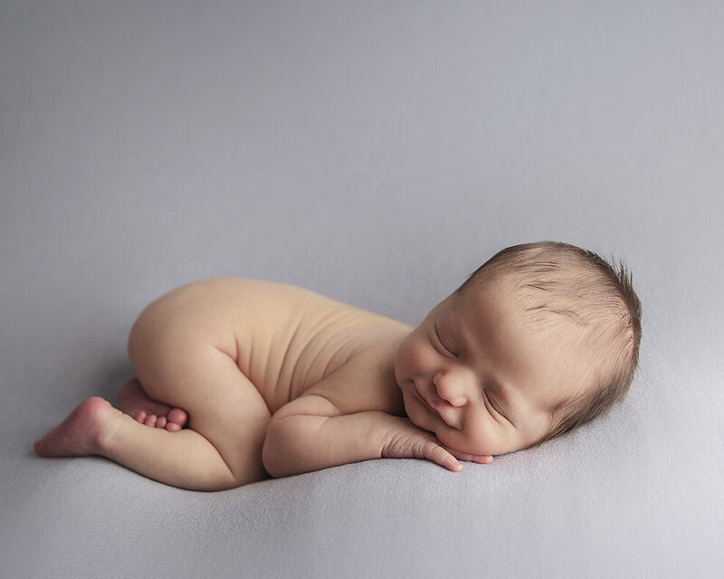 Newborn baby on blue blanket for newborn photoshoot.