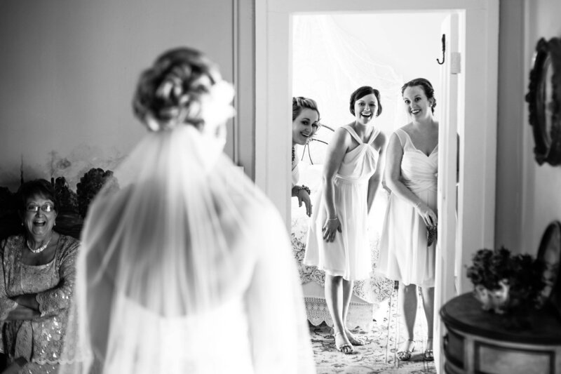Luxury Wedding Portraits by Moving Mountains Photography in NC - Black and white photo of bridesmaid first look of the bride.