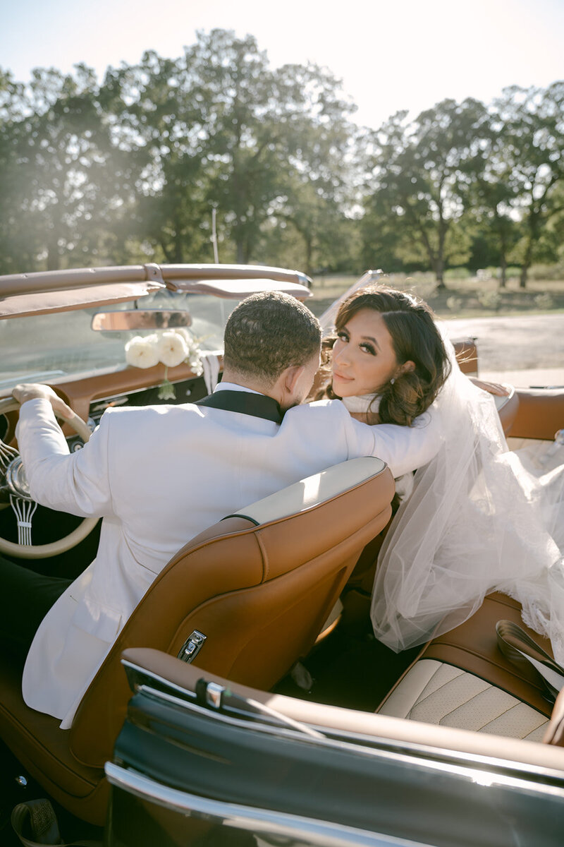 Just-married couple captured at Rosebridge Estate in a vintage convertible, photographed by Austin wedding photographer Erin Marcin.