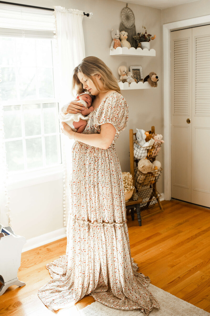baby girl in a white romper smiling while dad holds her and kisses the top of her head