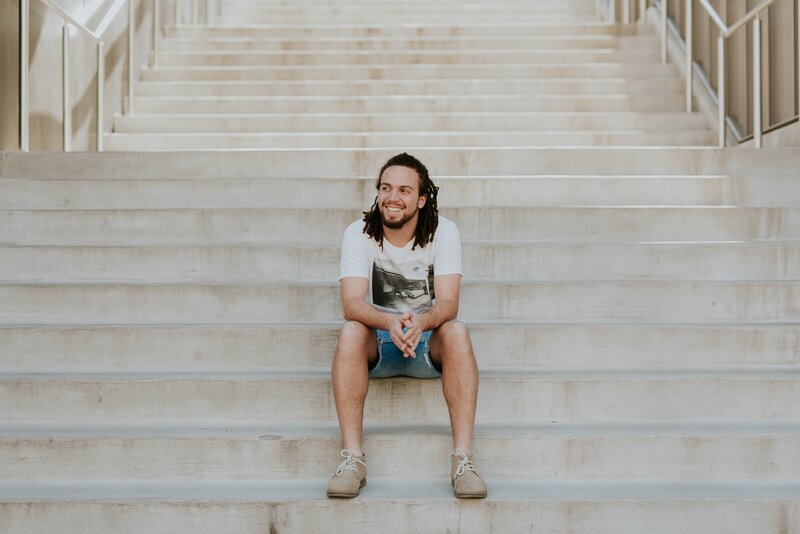 Young man sits on staircase
