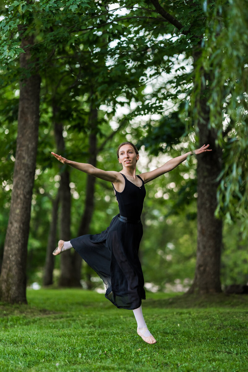 Jeune fille qui fait un saut de ballet  dans la forêt
