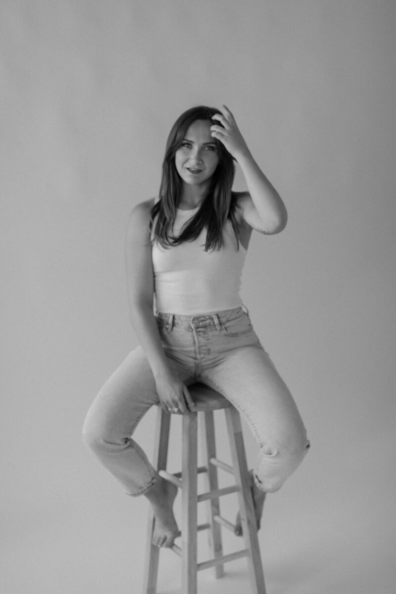 A person sitting in a chair with their hand in their hair 