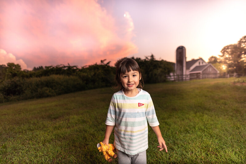 young girl on farm with barn in background