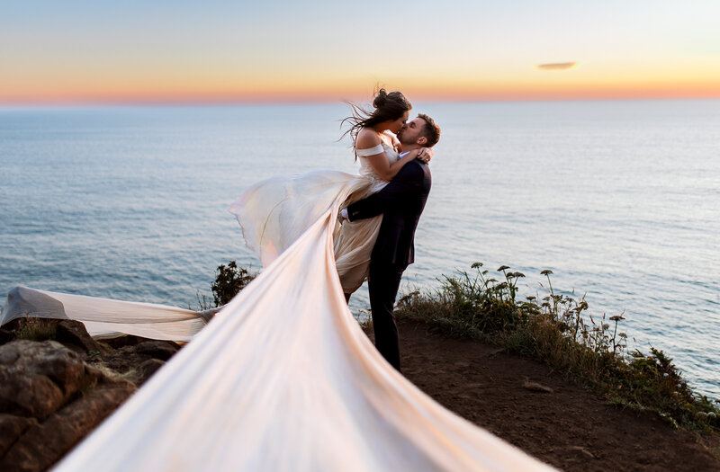 A stunning bridal portrait capturing the free-spirited essence of the Pacific Northwest coast, with windswept veils and breathtaking views