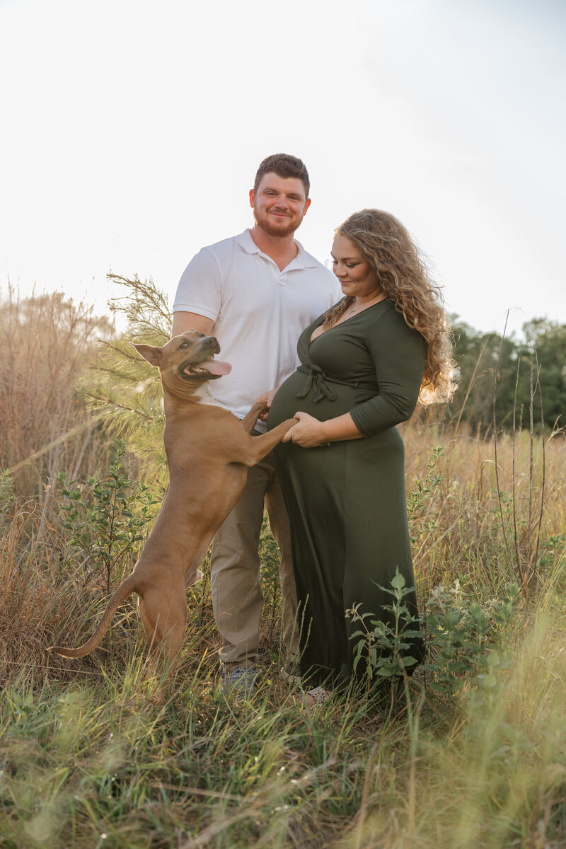 Pregnant Angelica poses in beautiful red dress  in forest outside Houston