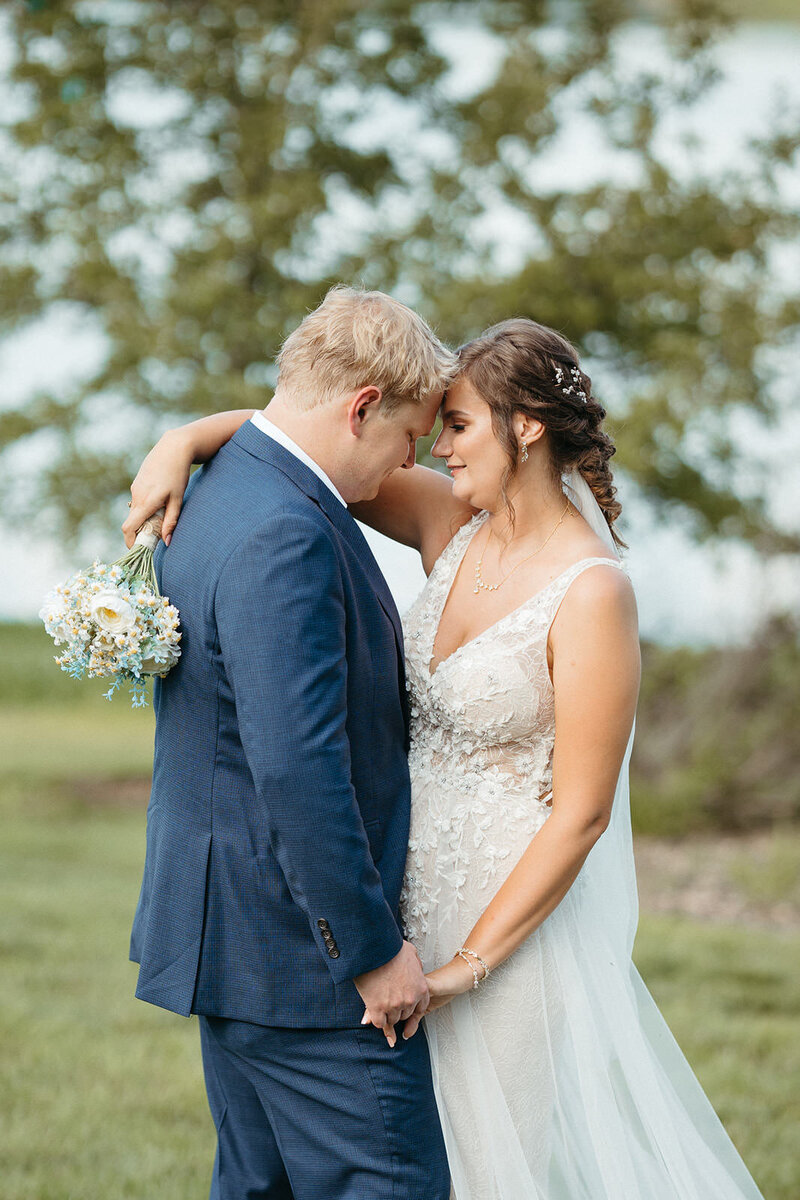A newlywed couple standing forehead to forehead 