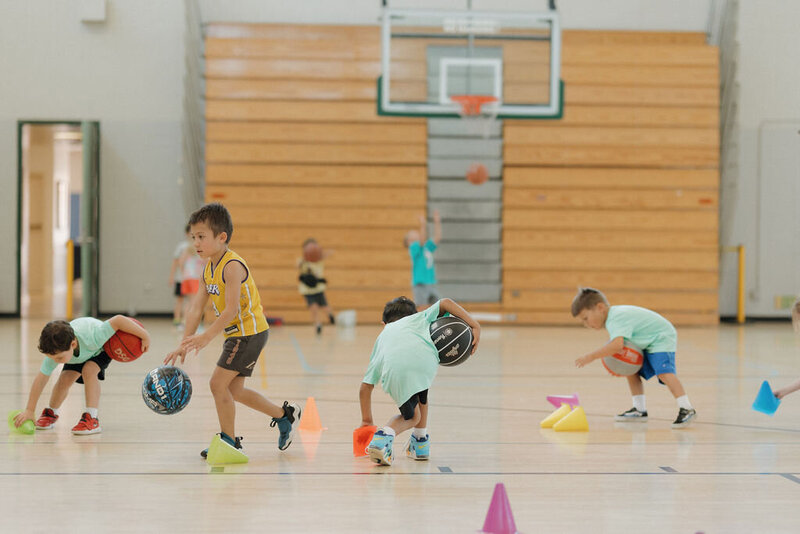 kid dribbling a soccer ball indoor at pley sports camp