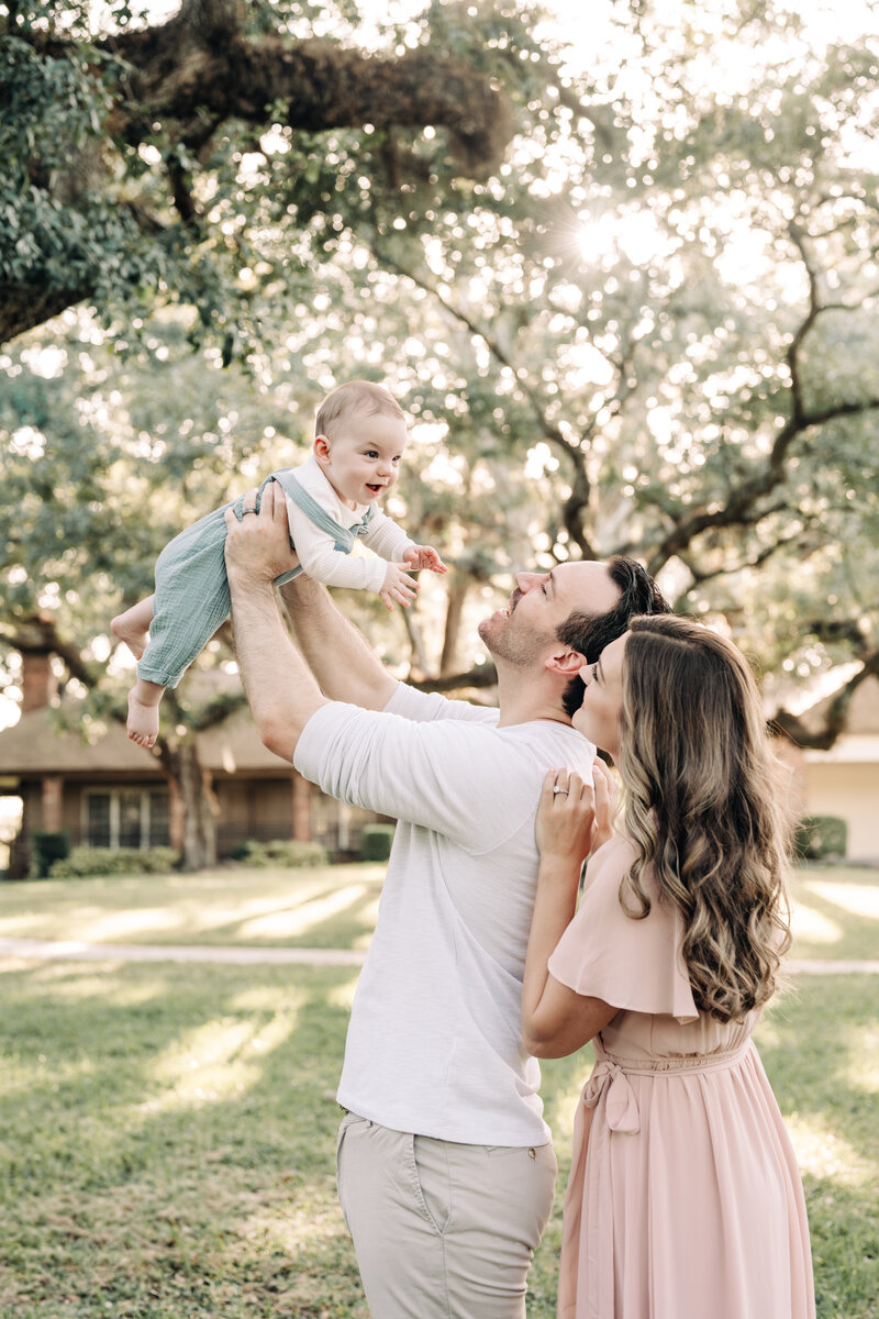 South Florida Family Photographer captures parents lifting their kid up in the air