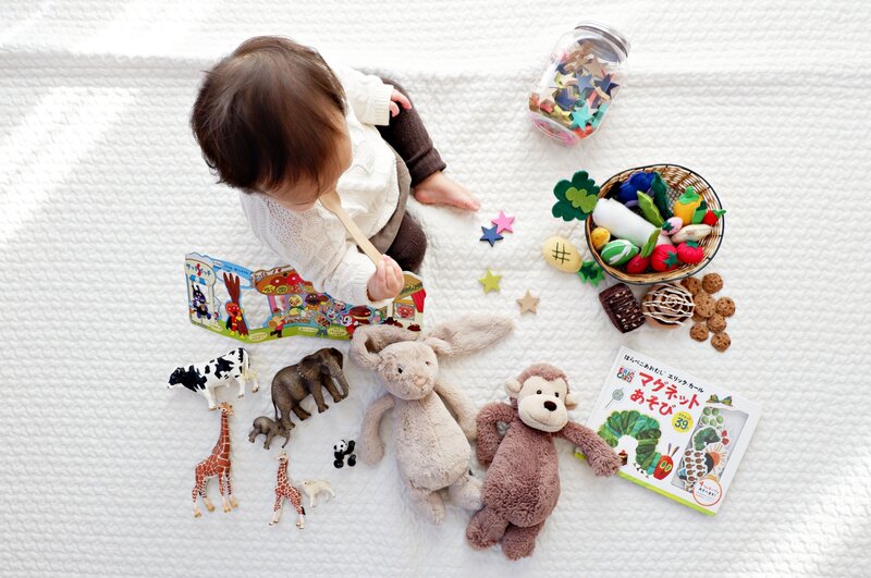 child on a soft mat surrounded by tactile toys