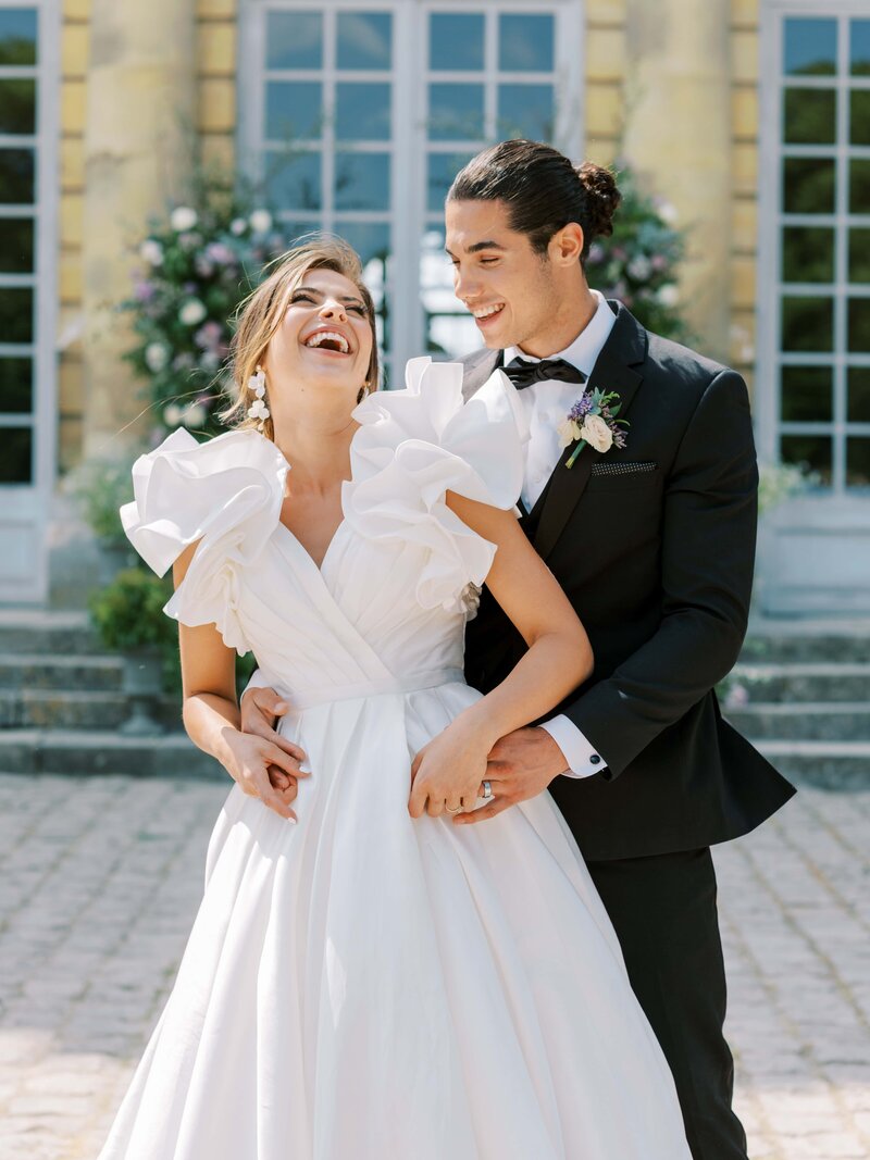 bride and groom laughing together with the dfw wedding photographer at the Château de champlâtreux