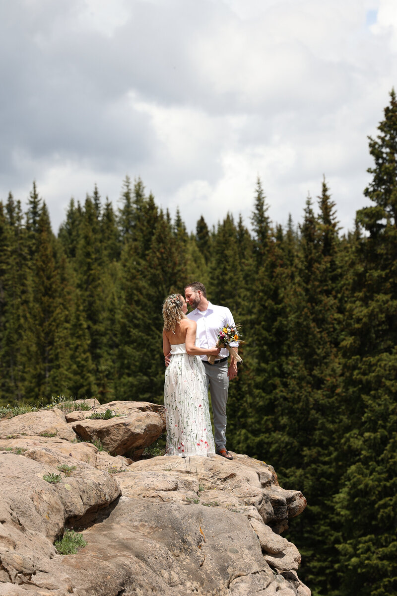 Bride and groom standing face to face holding lanterns at blue hour.