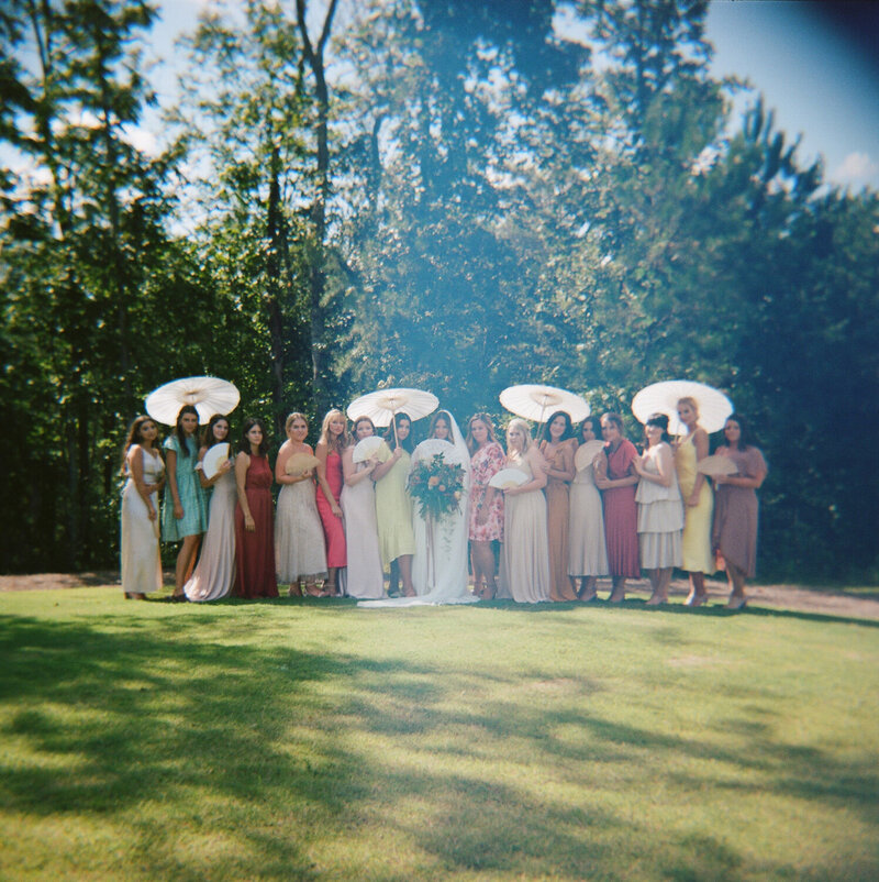 Bride with all Bridesmaids holding umbrellas