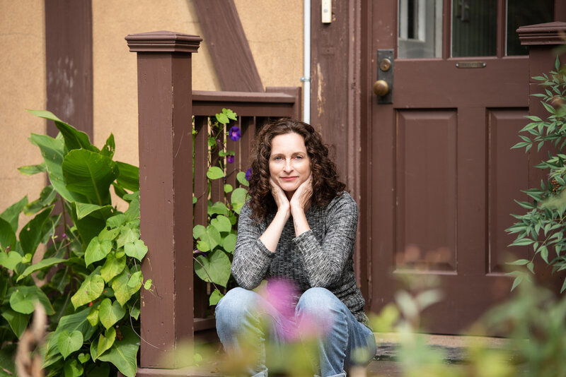 A person sitting on a staircase with her chin in her hands