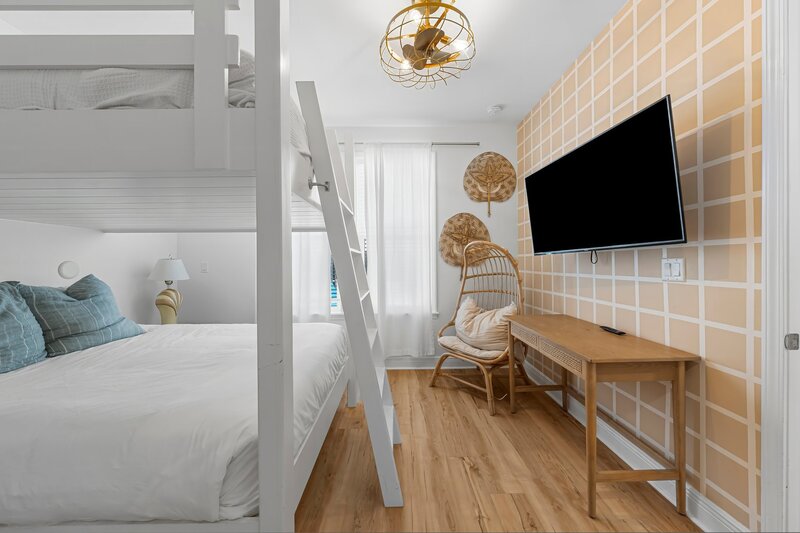 Chic bunk bedroom with smart TV and lounge chair at Beach Cabana in Panama City Beach, close to 30A vacation rentals and Santa Rosa Beach escapes.