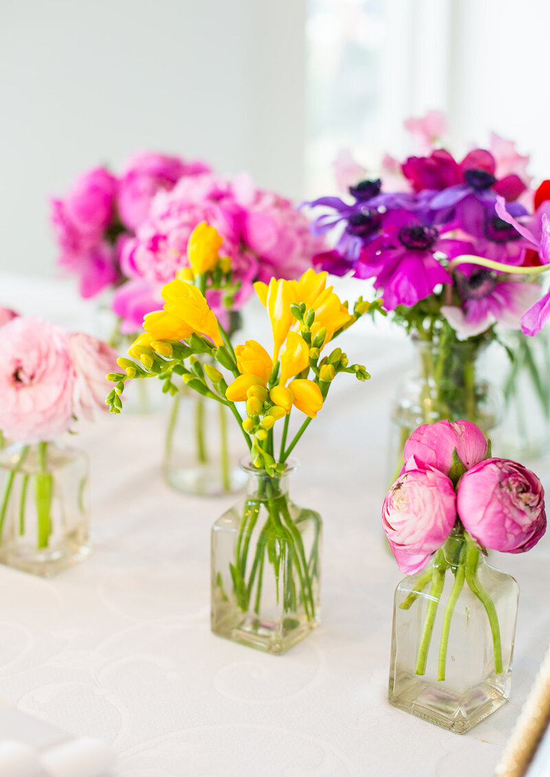gold and white place setting with white candles and white bouquets
