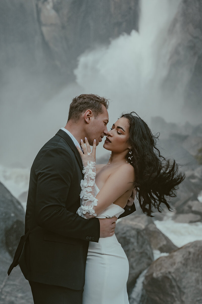 bride and groom kissing at yosemite falls