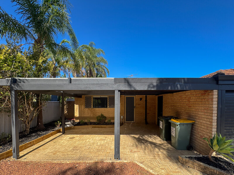 Front of cream brick house with painted dark grey pergola in Greenfields.