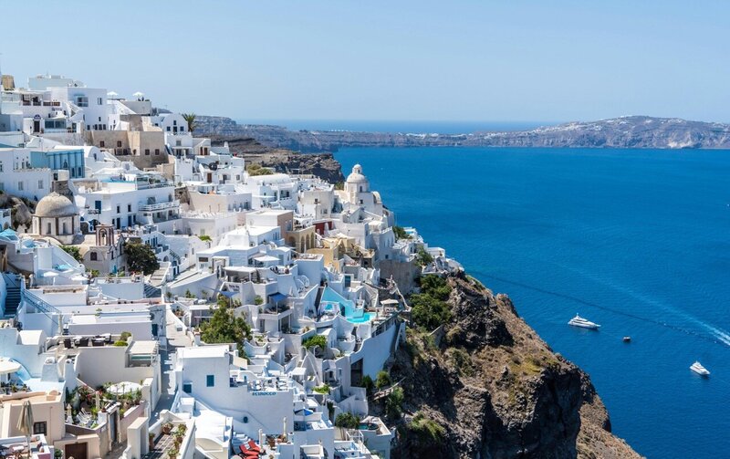 Whitewashed cliffside buildings in Santorini, Greece overlooking the Aegean Sea