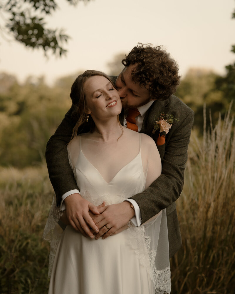 Married couple embracing in Wiltshire countryside