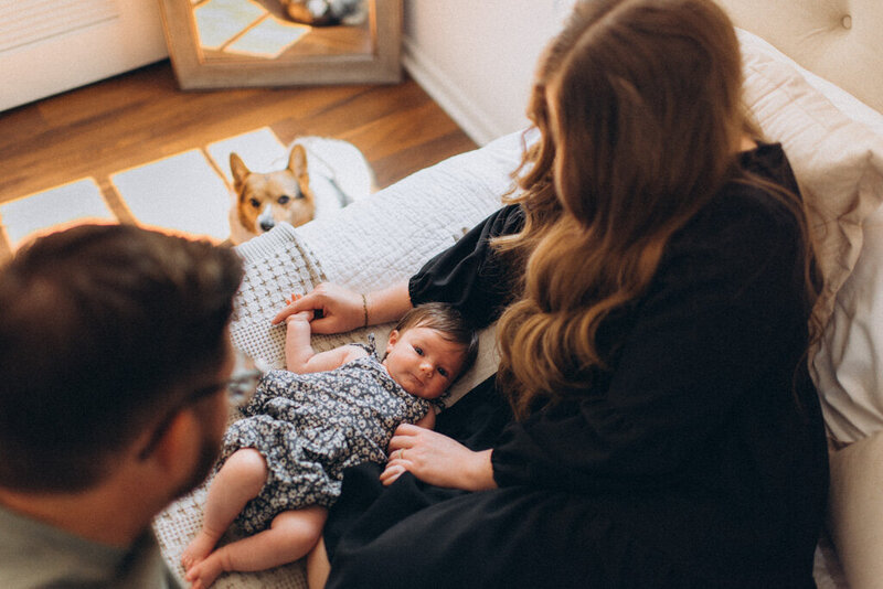 Mom looking down at baby on bed in Scottsdale
