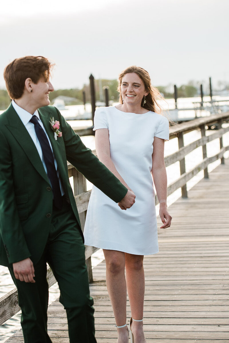 brides on boardwalk holding hands