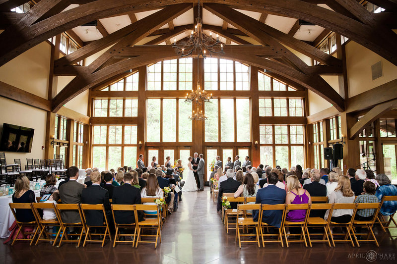 The inside of the Donovan Pavilion set up for an indoor wedding ceremony in front of the huge wall of windows in Vail Colorado
