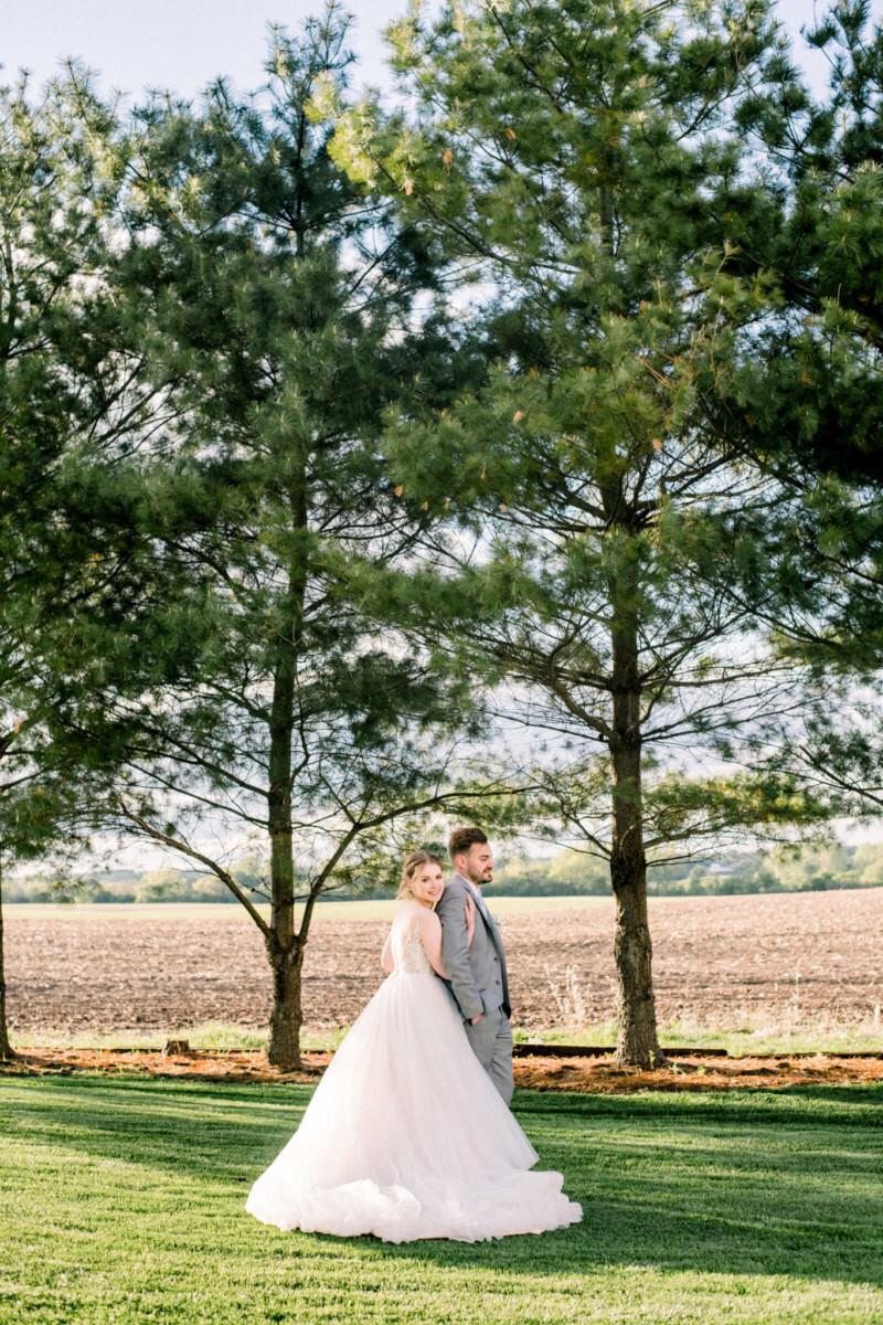Bride and groom embrace in a field at Lincoln Farmstead