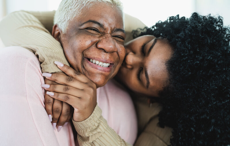 Generations of live. A daughter showing affection with her mother.