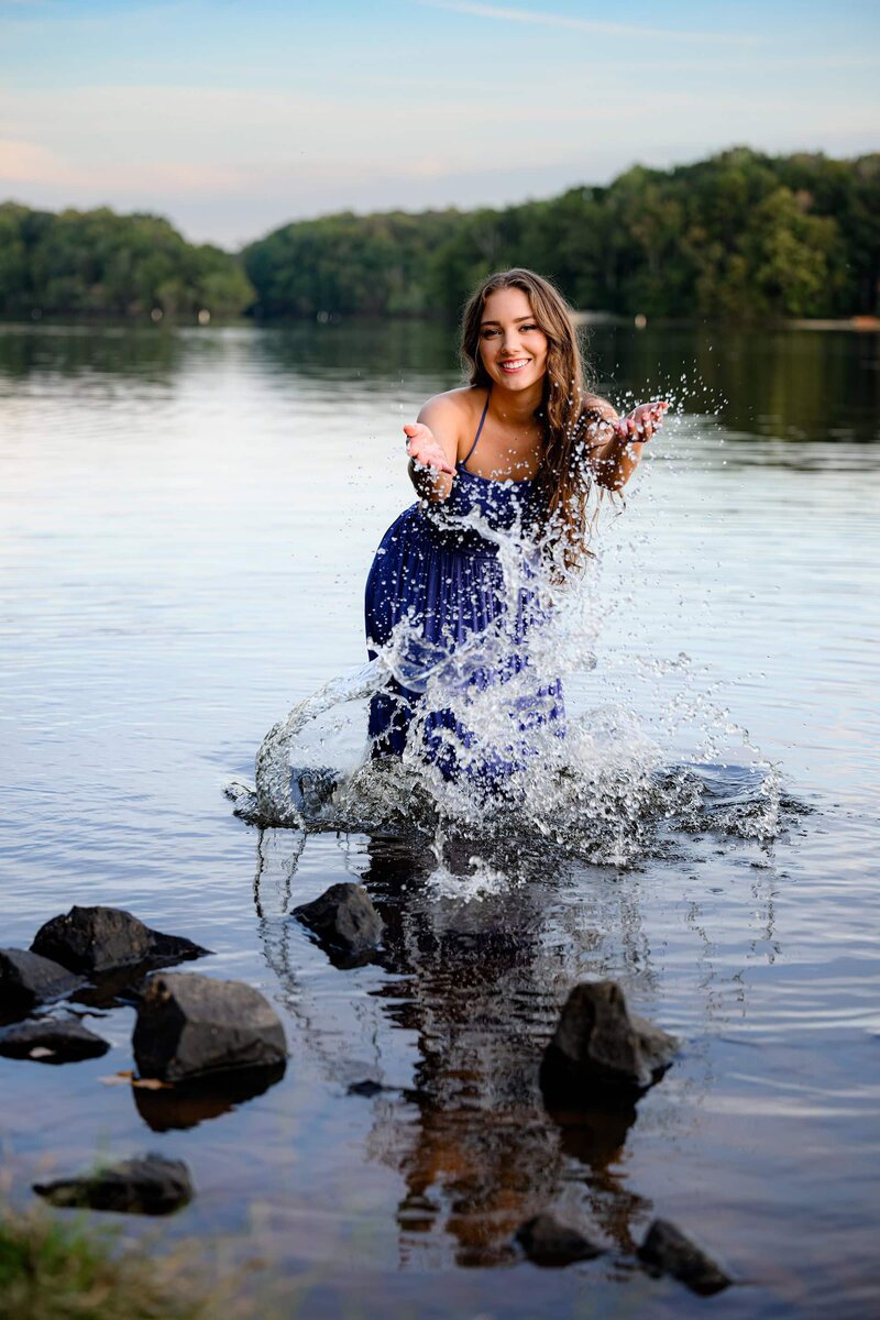 senior splashes water during her grrad sessiion
