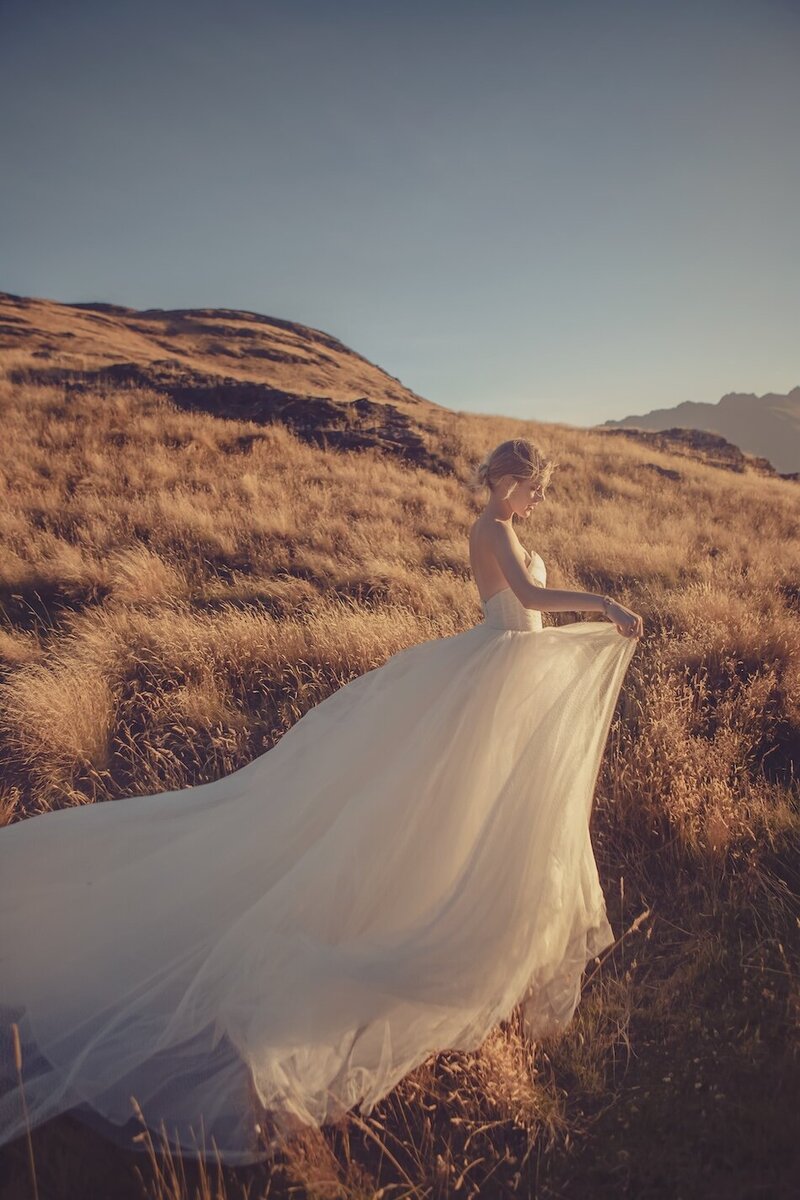 A golden light outdoor photoshoot of a woman wearing a couture dress.