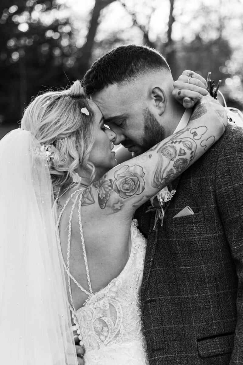 Bride & Groom embrace touching foreheads with closed eyes
