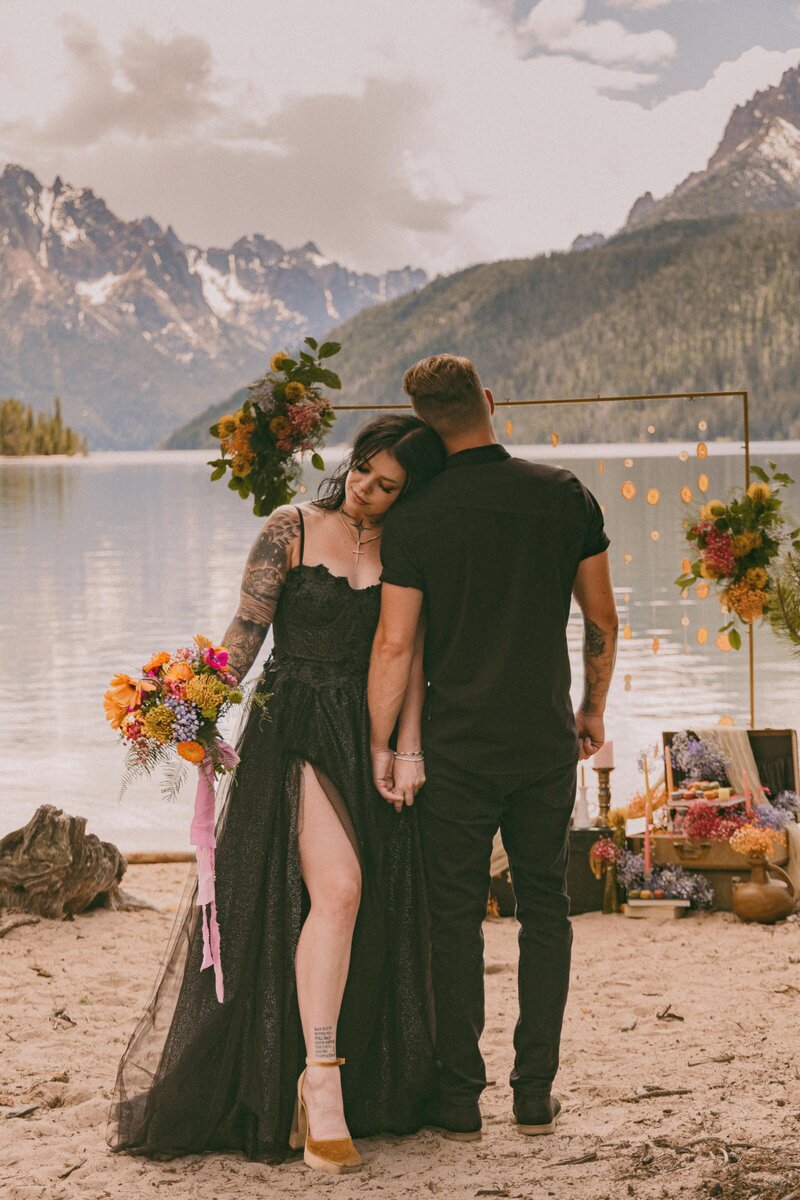 Couple holding hands near mountain lake in Idaho at their elopement