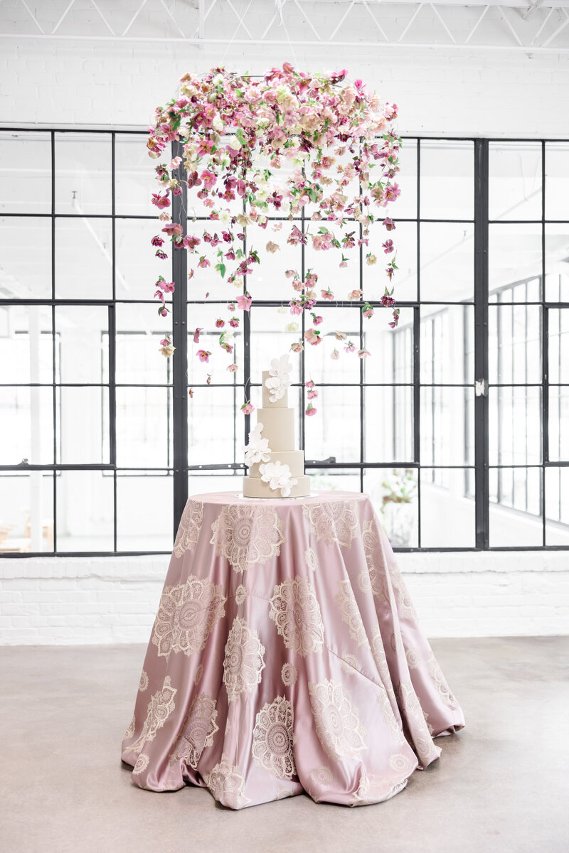 hanging pink flowers over a cake
