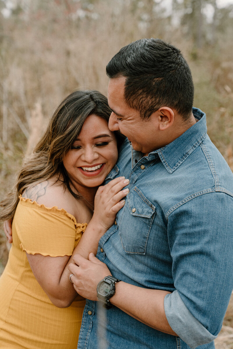 Maternity photos of couple holding eachother close and laughing.
