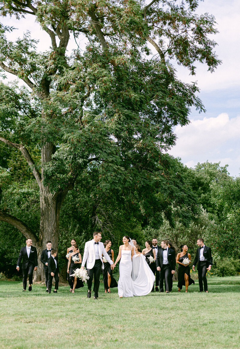 formal wedding party walking under old oak trees at a local destination wedding venue upstate
