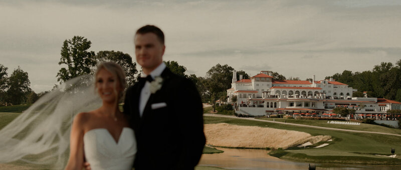 Bride and groom standing in front of congressional country club