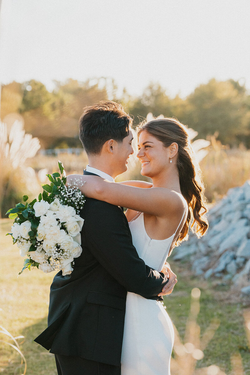 A bride and groom smiling at one another after getting married.