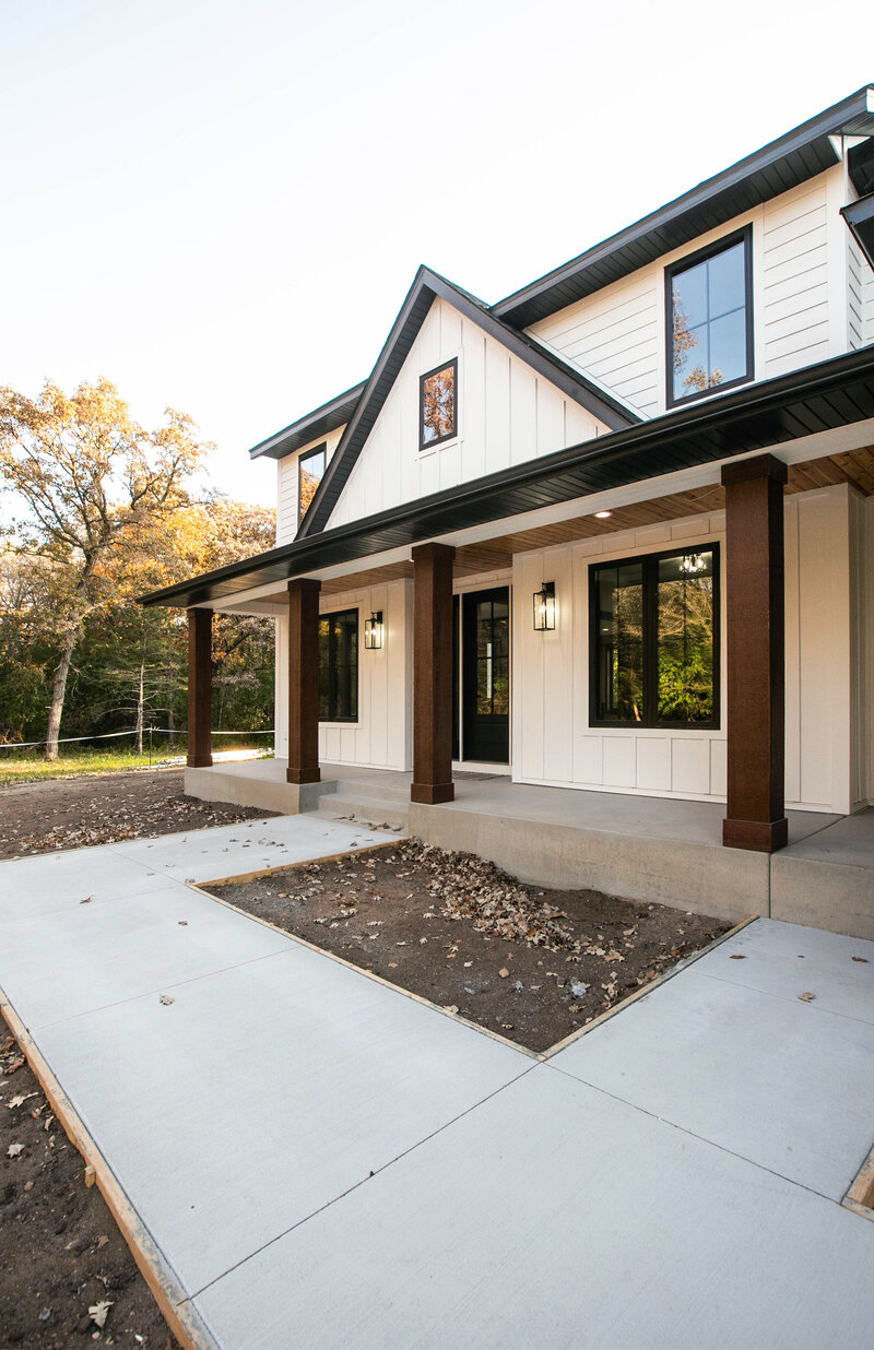 Custom Minnesota Home built by Cornerstone Custom Builds with cream siding and dark wood pillars.