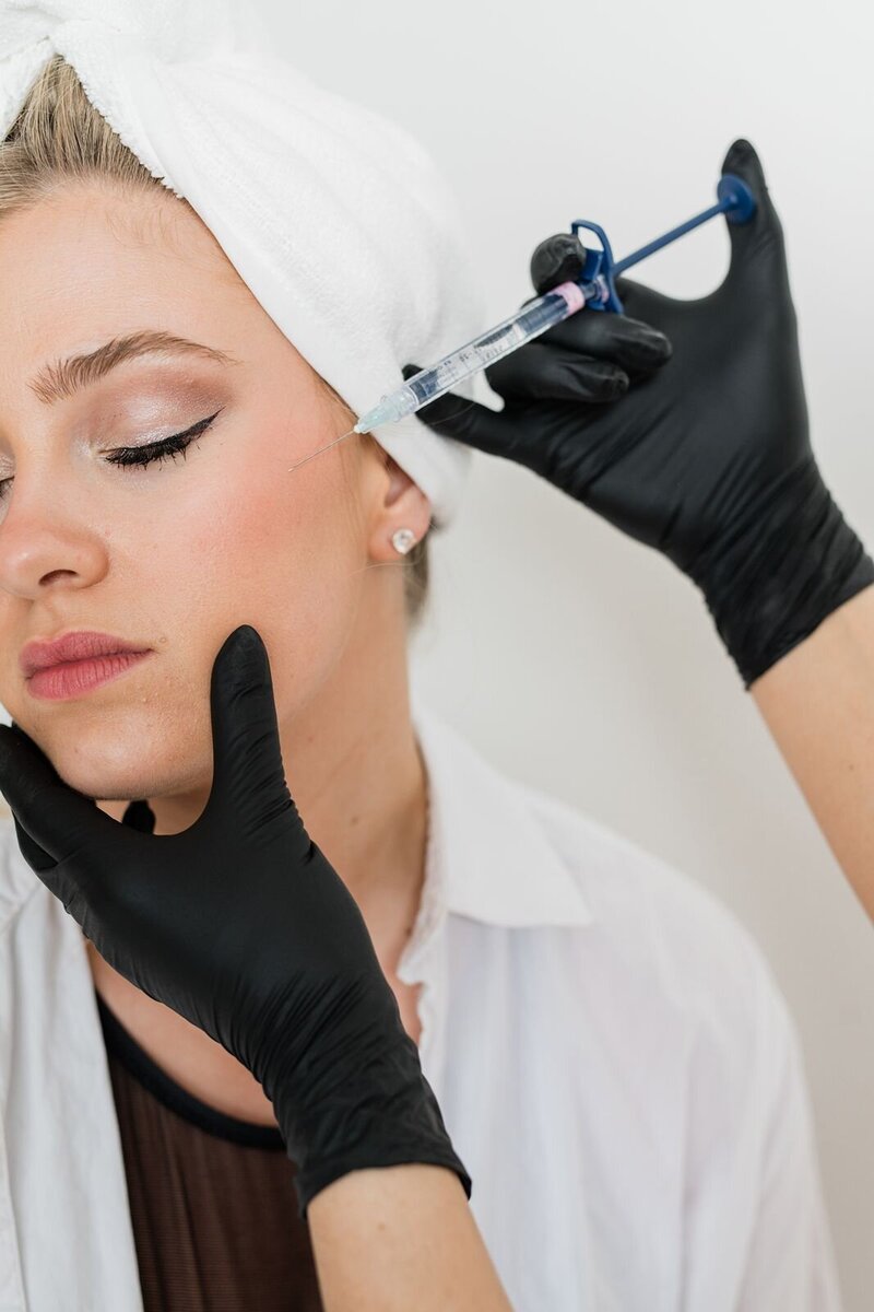 Esthetician uses hard wax to wax the hair off of client's leg