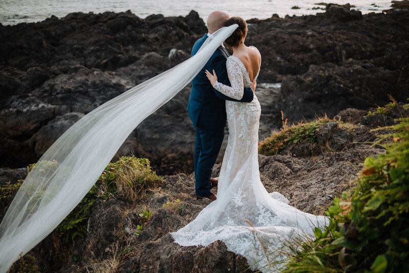 Vancouver Island Wedding photographer, Megan Maundrell Photography, takes a photo of a couple snuggled up under a willow tree in Beacon Hill Park before their ceremony.